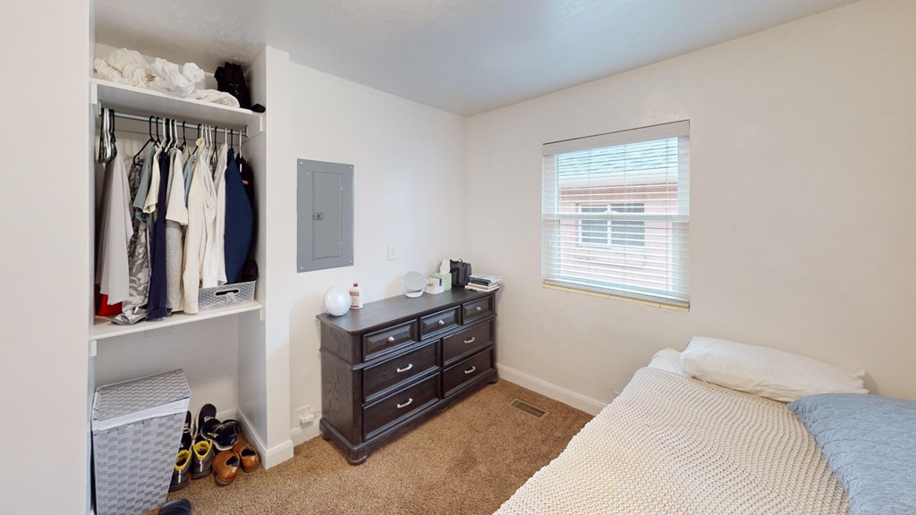 A bedroom with a bed, dresser, and closet.