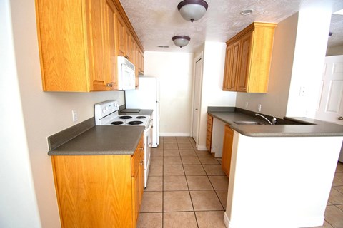 A kitchen with wooden cabinets and a black countertop.