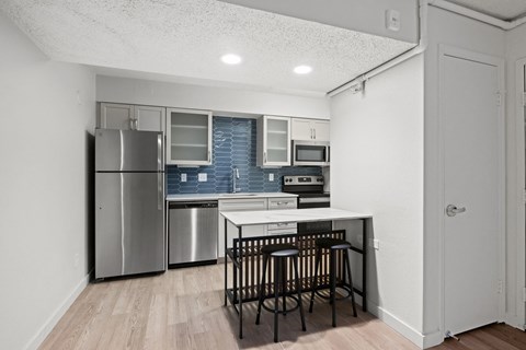 a kitchen with a island and a stainless steel refrigerator at AVIA Lofts on Liberty Ridge Apartments, Jacksonville, Florida