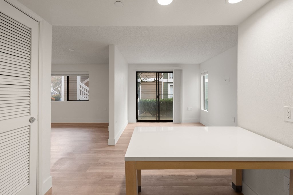 A white table is in a room with a white wall and a white door at AVIA Lofts on Parkway Apartments, Vancouver