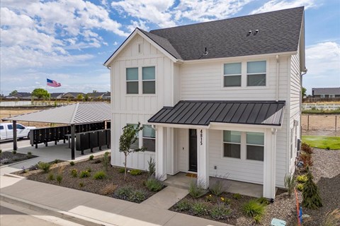 A white house with a black roof and a covered patio area. at Alante Homes at Spring Run, Caldwell, ID, 83607