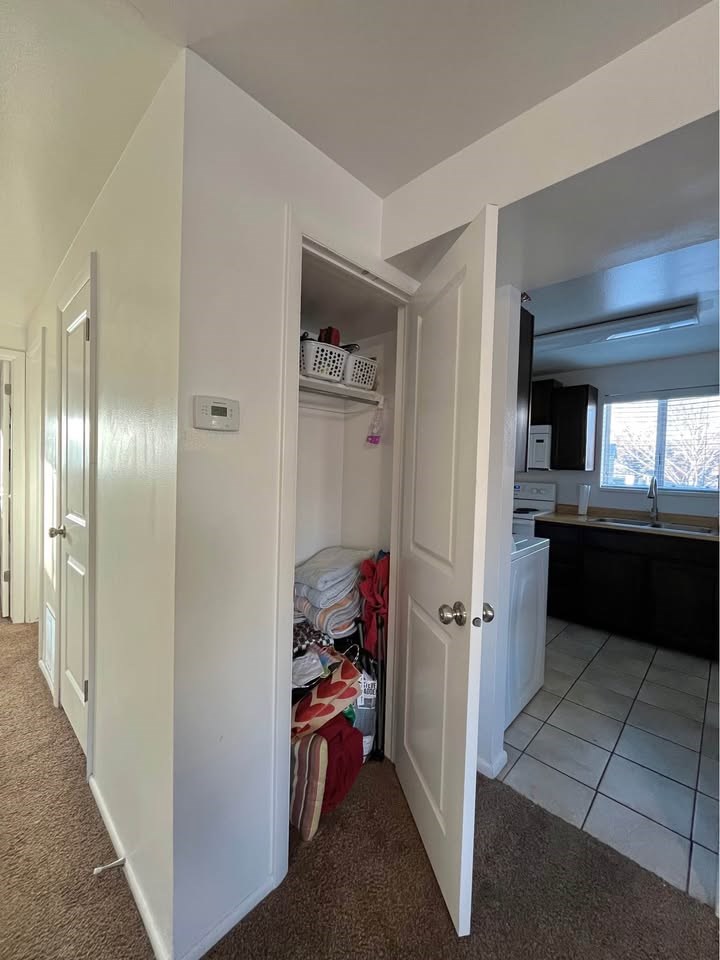 A hallway with a door open to a kitchen.