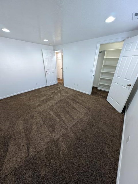A room with brown carpet and white walls.