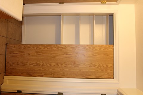 A wooden cabinet with a white drawer is shown.