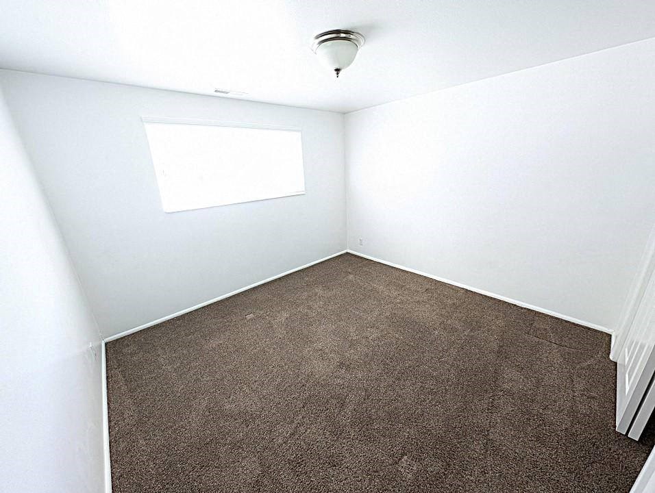 A room with a carpeted floor and a window.