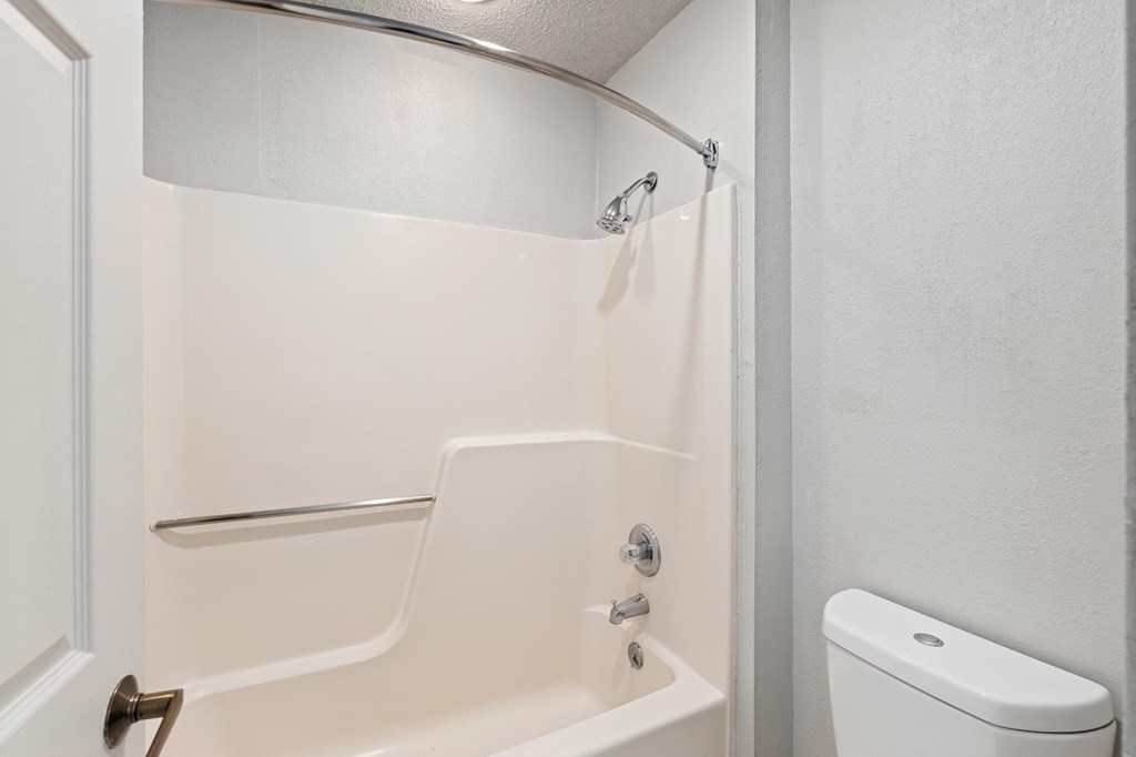 a white bathroom with a shower and a toilet