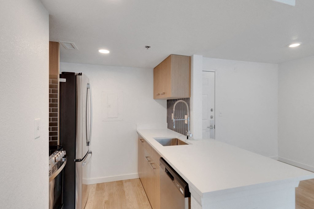 a kitchen with a white counter top and a refrigerator