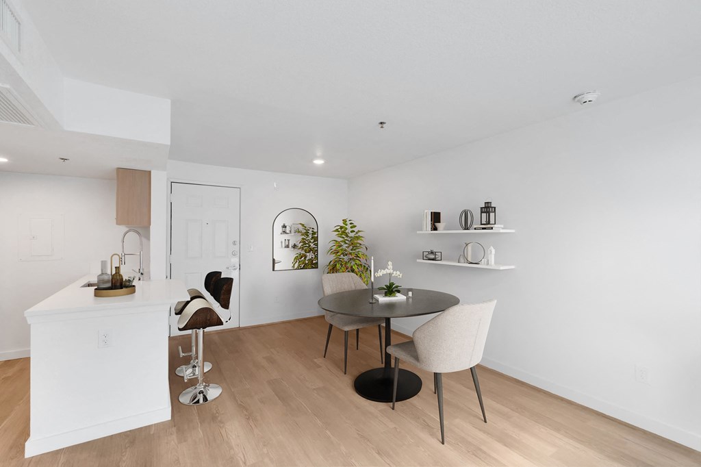 a dining area with a table and chairs and a kitchen