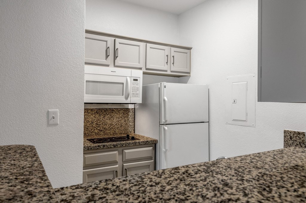 a kitchen with granite counter tops and white appliances