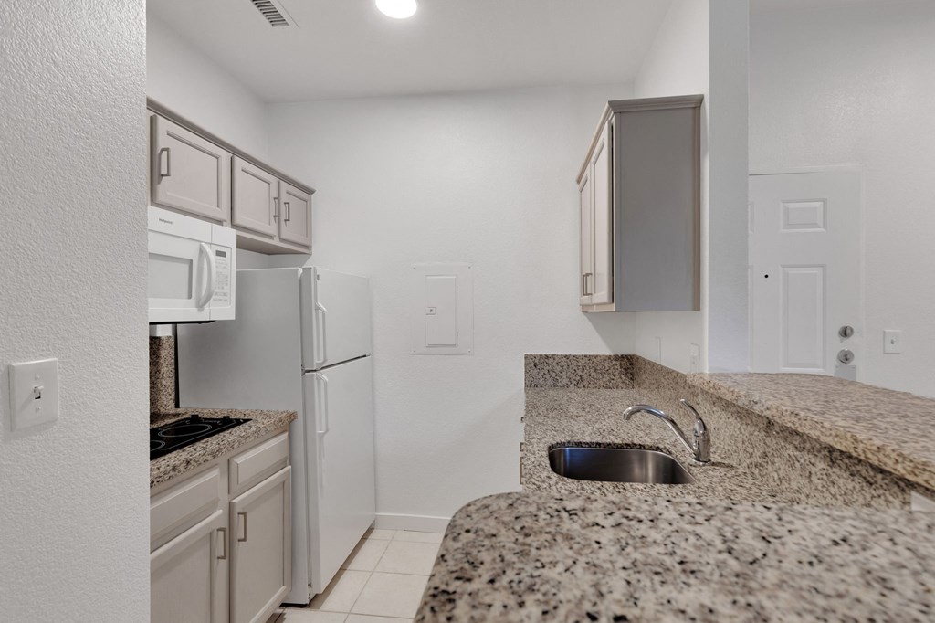 a kitchen with granite counter tops and white appliances