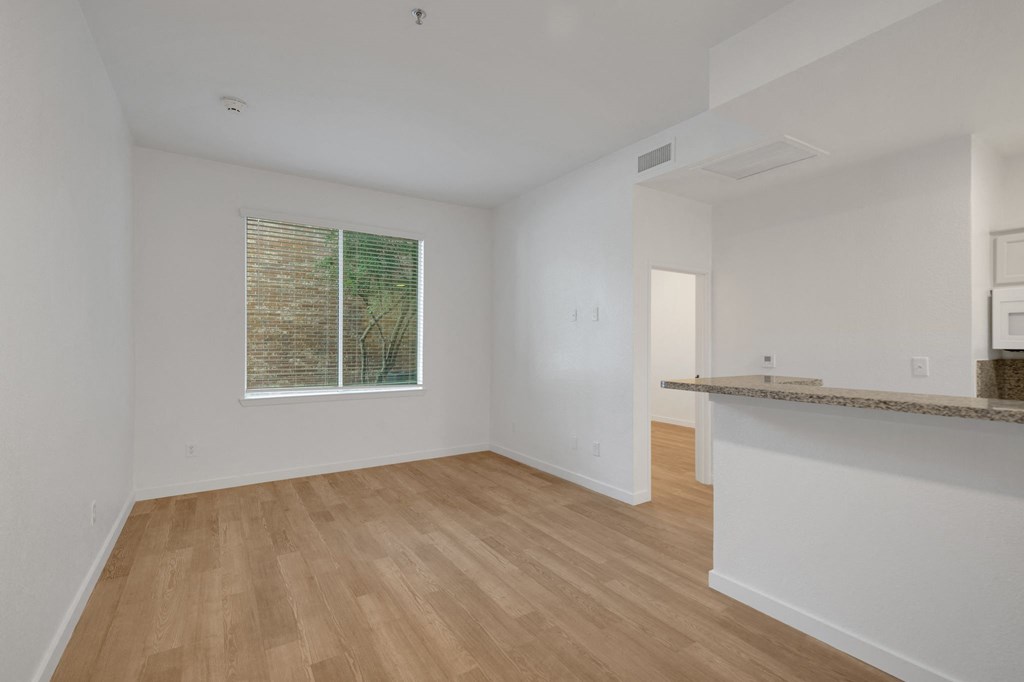 an empty living room with white walls and a window