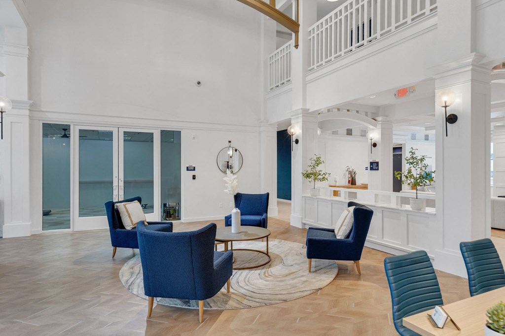 a living room with blue chairs and a table with chairs