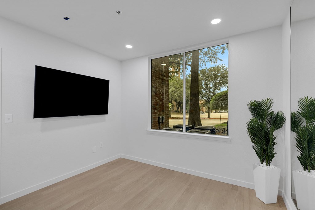 a living room with a large window and a tv on the wall
