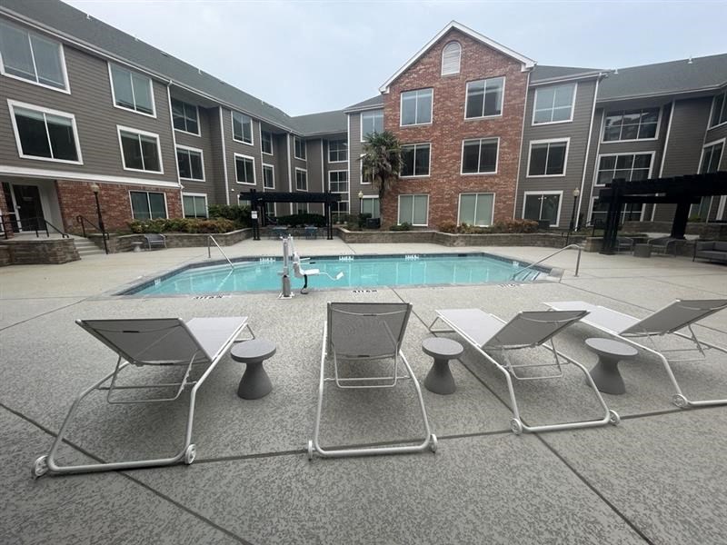 an apartment building with a swimming pool and chairs