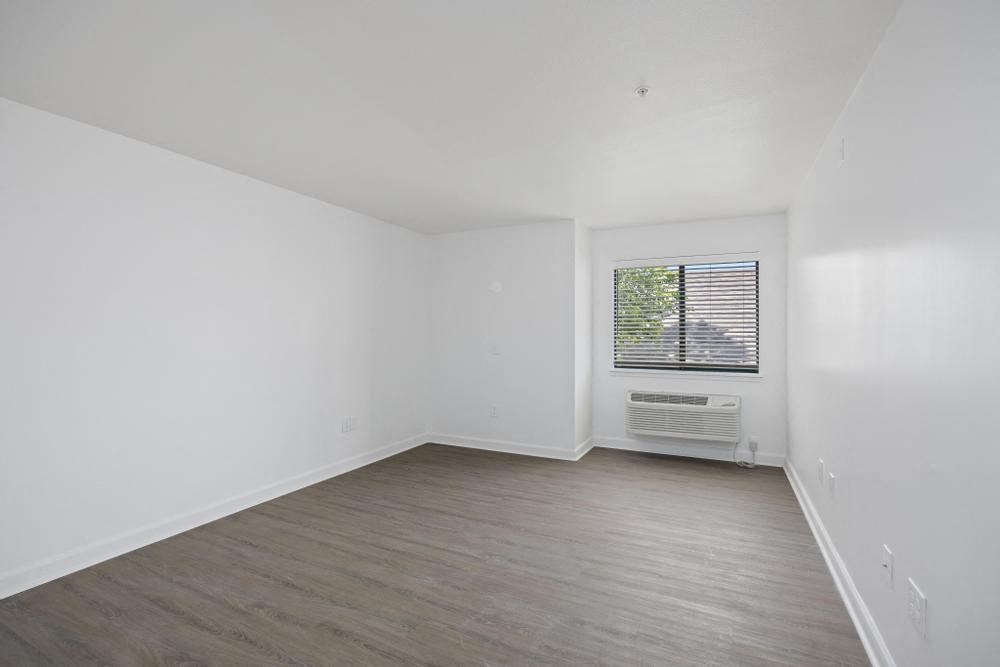 an empty room with white walls and a window