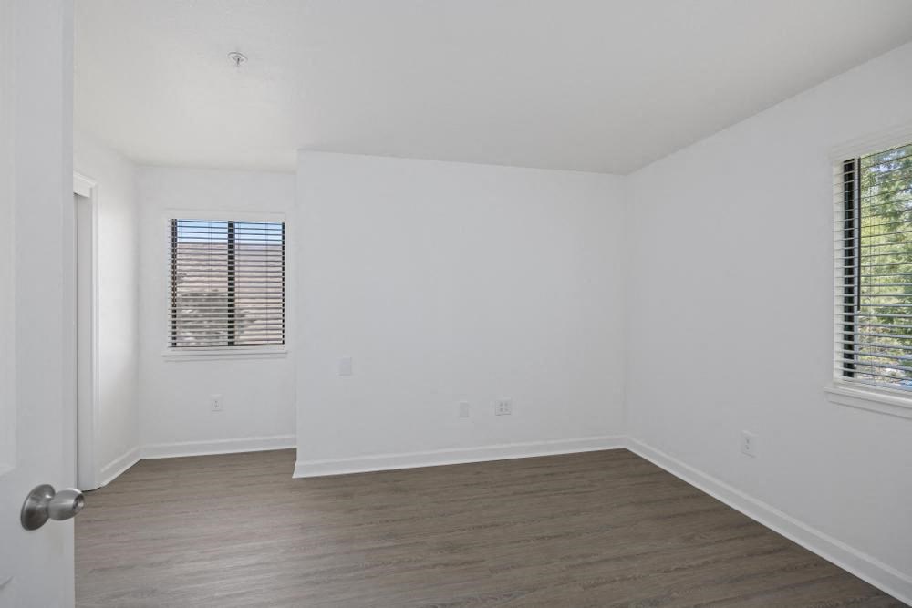 a bedroom with white walls and wood floors