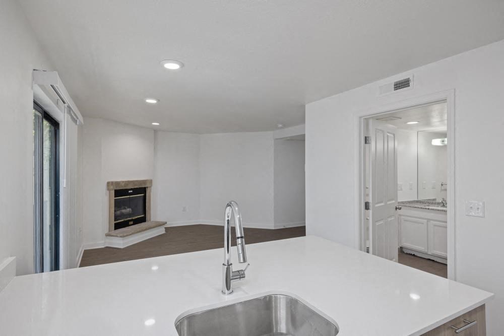 a kitchen with a sink and a fireplace in the background