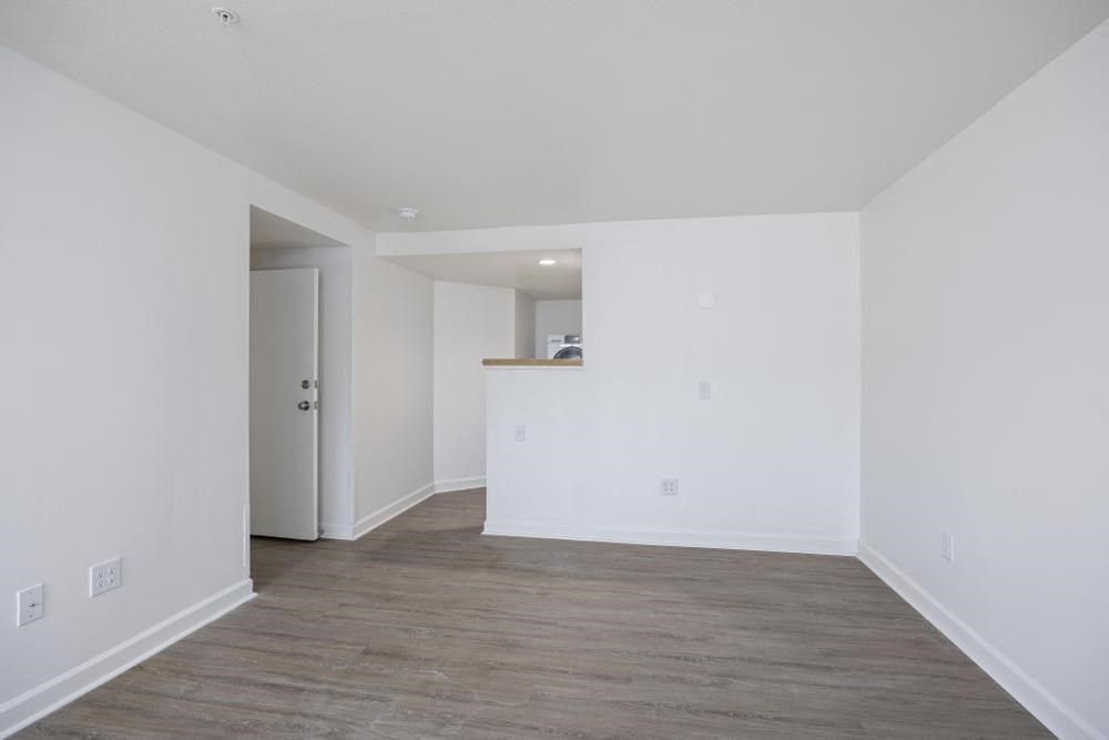 an empty room with white walls and a wooden floor