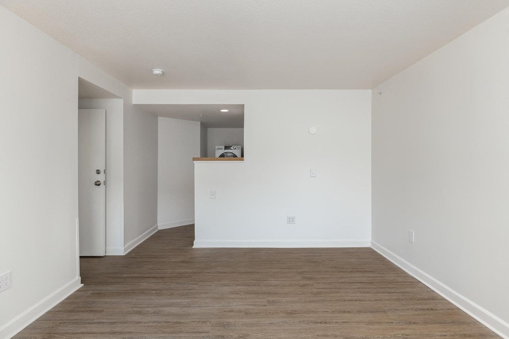 a bedroom with white walls and a wooden floor