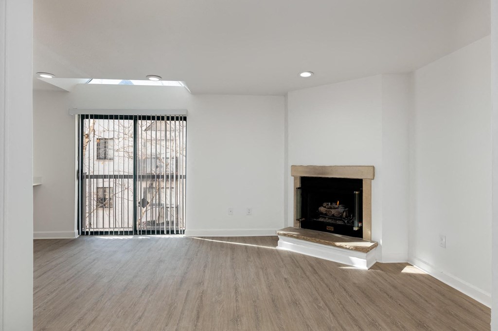 a living room with white walls and a fireplace