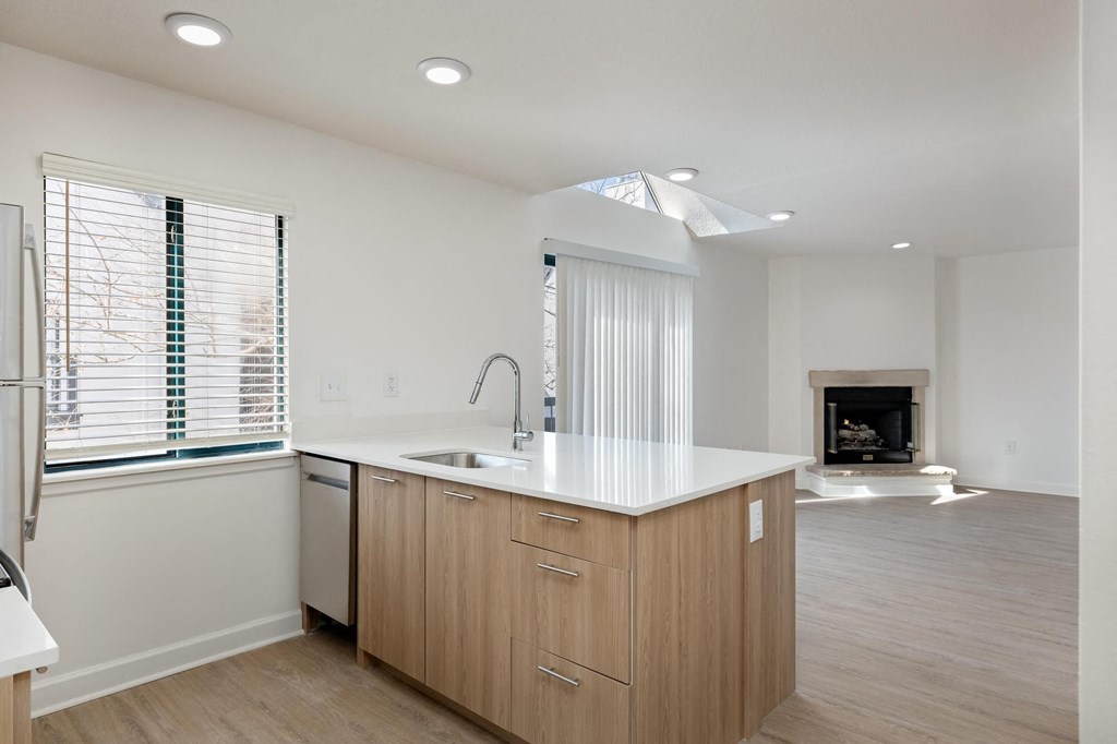 a kitchen with a large island and a fireplace in the background