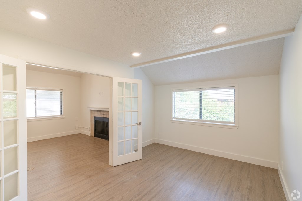 an empty living room with a fireplace and a white door