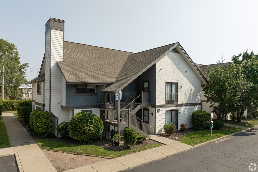 an exterior view of a white house with a porch and a staircase
