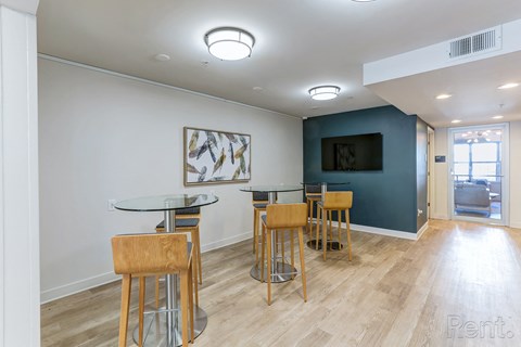 a common area with tables and chairs and a television