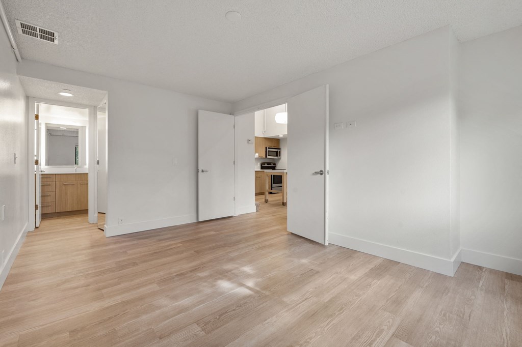 a living room and kitchen with wood floors and white walls at AVIA Lofts on Parkway Apartments, Washington, 98662