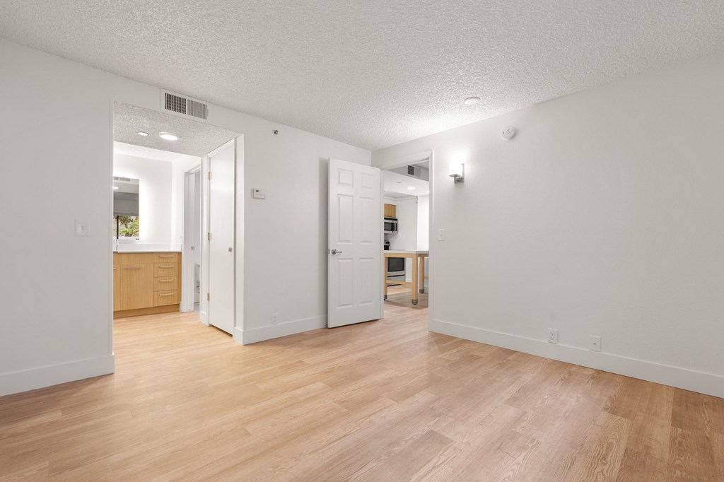 a living room and kitchen with wood flooring and white walls at AVIA Lofts on Parkway Apartments, Washington