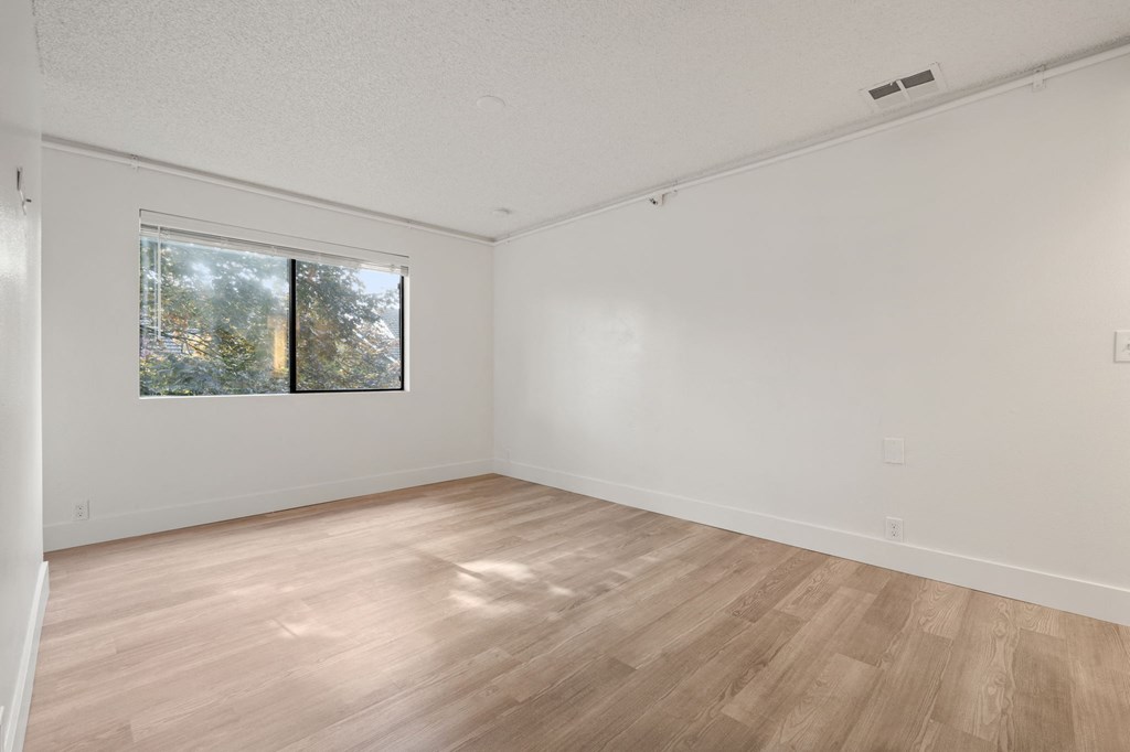 a spacious living room with wood floors and a window at AVIA Lofts on Parkway Apartments, Vancouver, WA