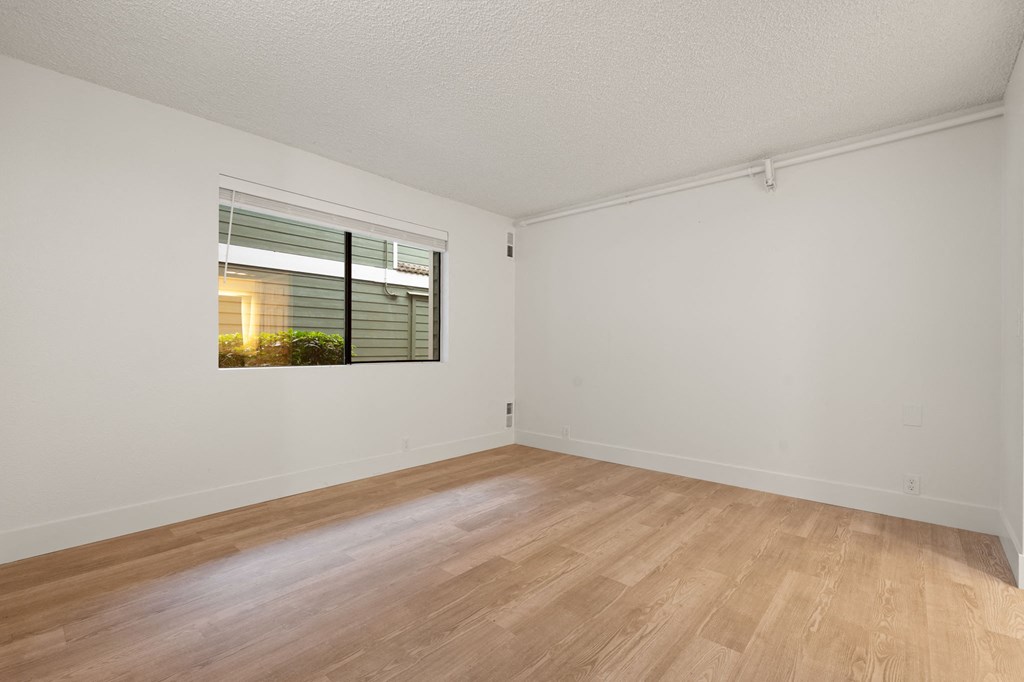 a spacious living room with a window and wood flooring at AVIA Lofts on Parkway Apartments, Vancouver, WA
