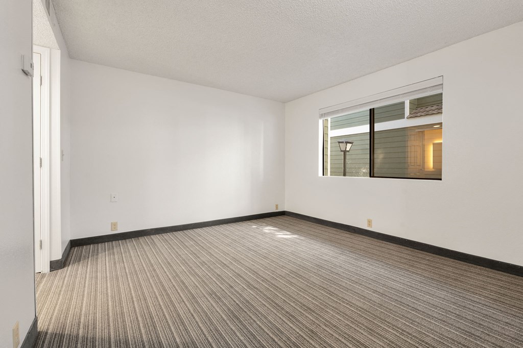 the living room of an empty apartment with a window at AVIA Lofts on Parkway Apartments, Washington