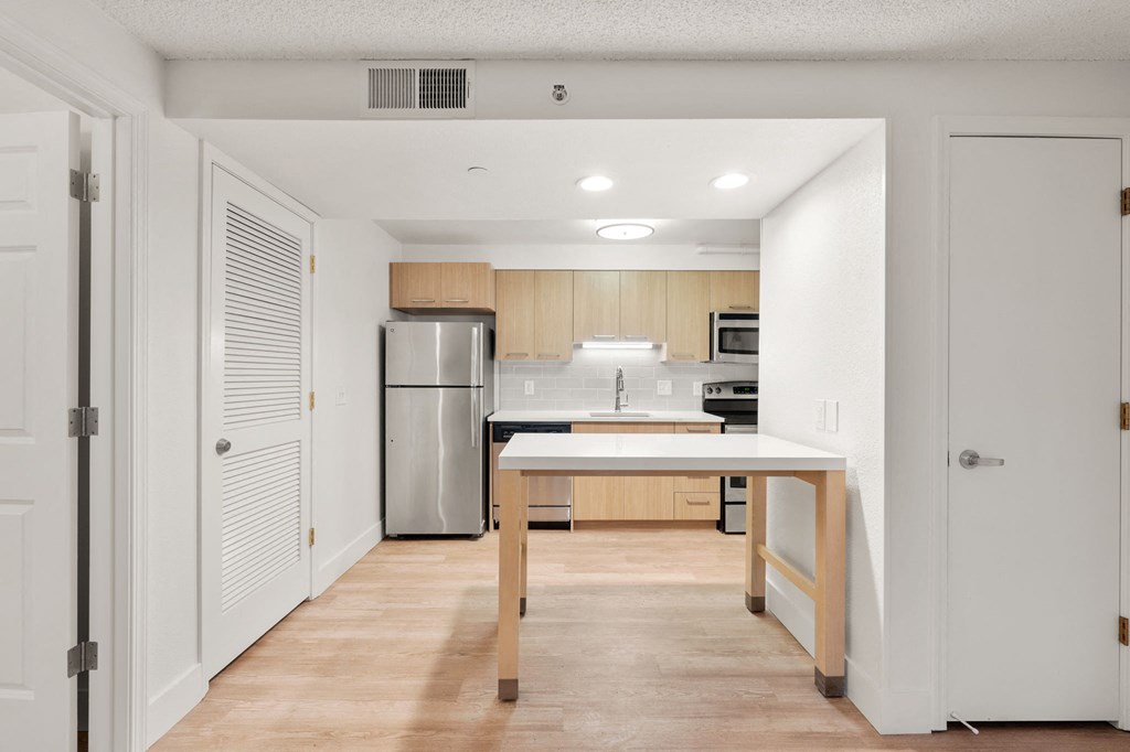 a kitchen with a large island and a stainless steel refrigerator at AVIA Lofts on Parkway Apartments, Washington, 98662