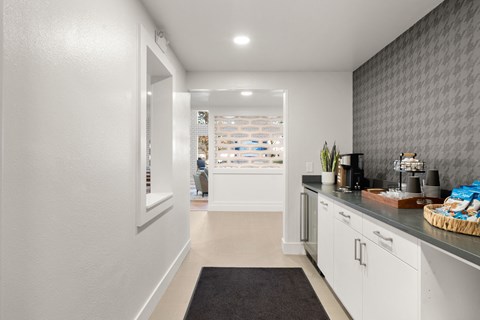 a kitchen with white cabinets and a counter top and a door to a store
