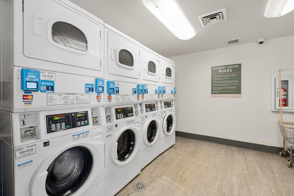 a washer and dryer machine in a laundry room with other washing machines at AVIA Lofts on Parkway Apartments, Washington, 98662