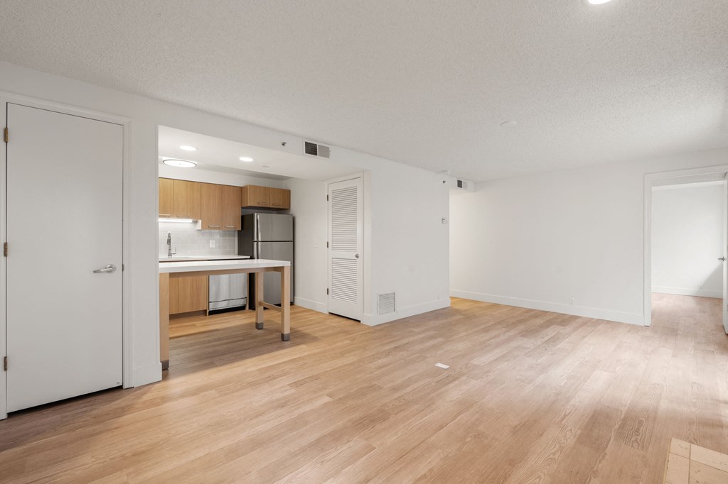 the living room and kitchen of an apartment with a hardwood floor and a kitchen at AVIA Lofts on Parkway Apartments, Vancouver, WA, 98662