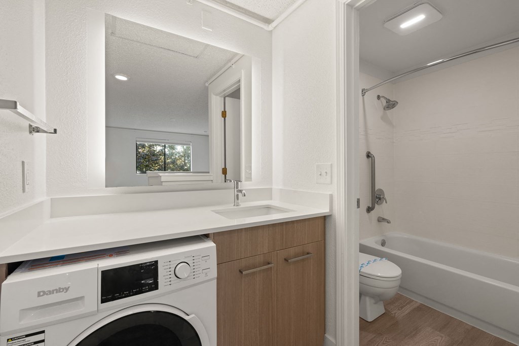 a laundry room with a sink and a washer and dryer in a house at AVIA Lofts on Parkway Apartments, Vancouver, WA