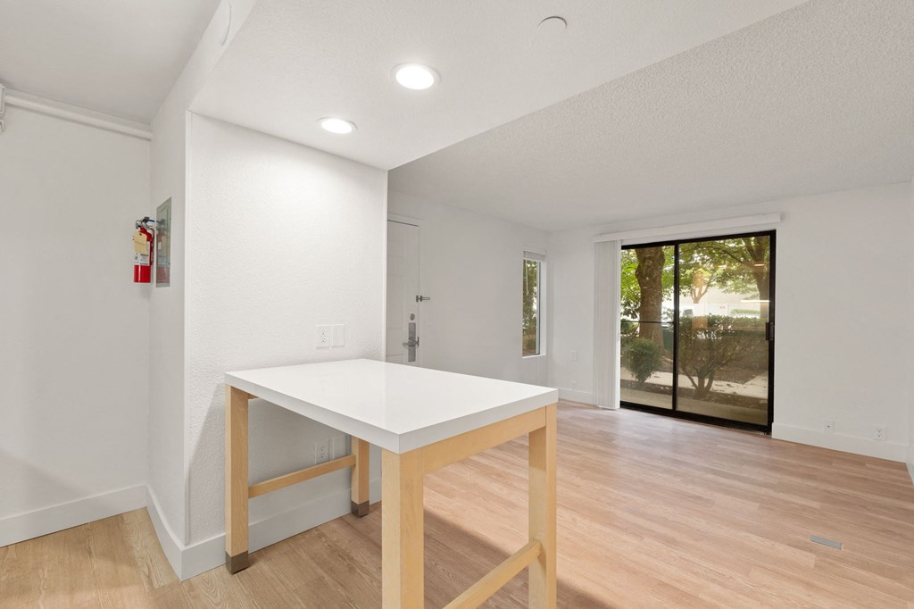 a kitchen with a white counter top and a sliding glass door at AVIA Lofts on Parkway Apartments, Vancouver, Washington