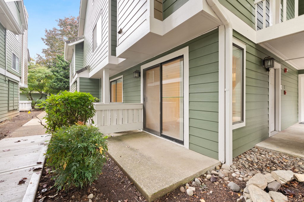 the entrance to a green house with a sidewalk and a glass door at AVIA Lofts on Parkway Apartments, Washington
