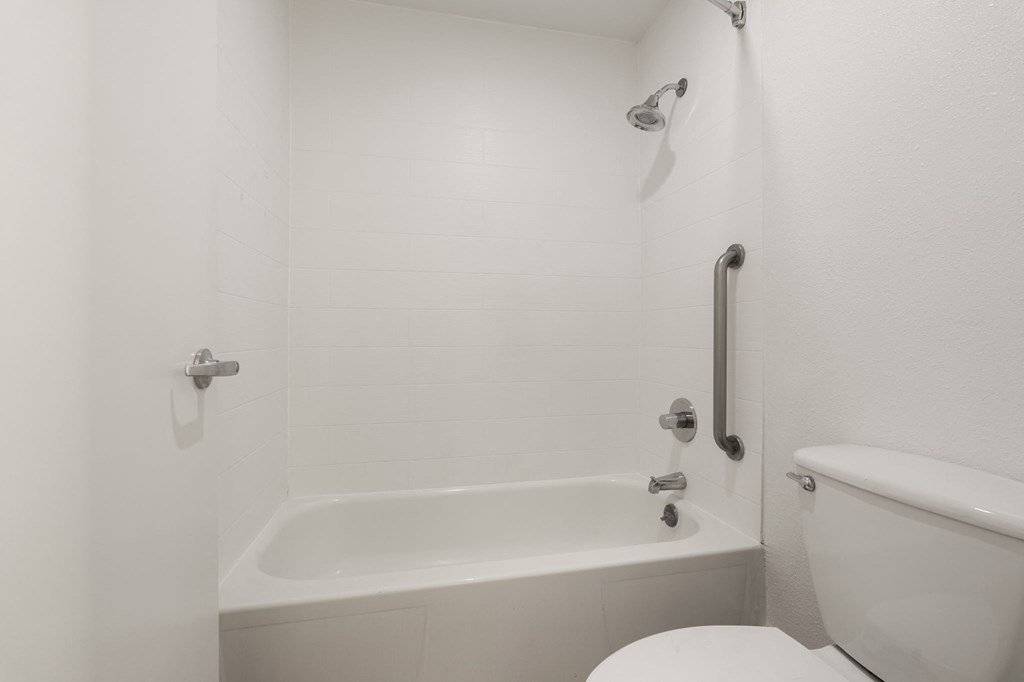 a white bathroom with a tub and a toilet at AVIA Lofts on Parkway Apartments, Washington, 98662