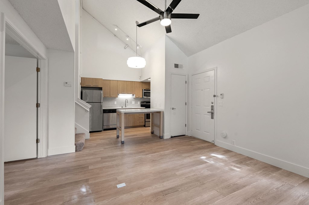 an empty living room and kitchen with a ceiling fan at AVIA Lofts on Parkway Apartments, Vancouver, Washington