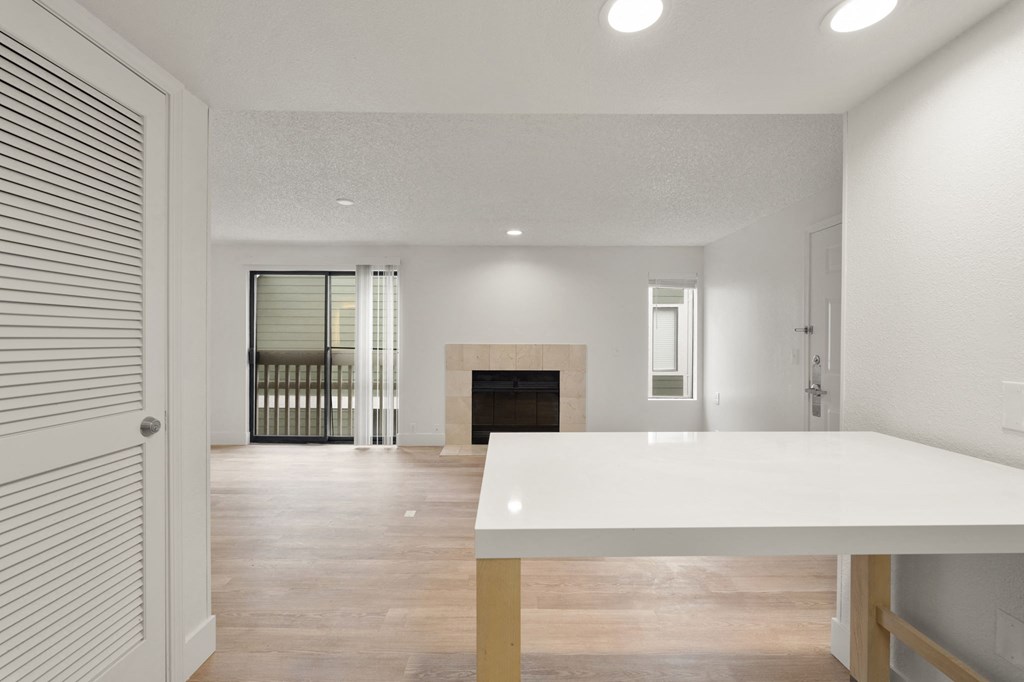 the living room and dining room of a house with a white table and a fireplace at AVIA Lofts on Parkway Apartments, Washington, 98662