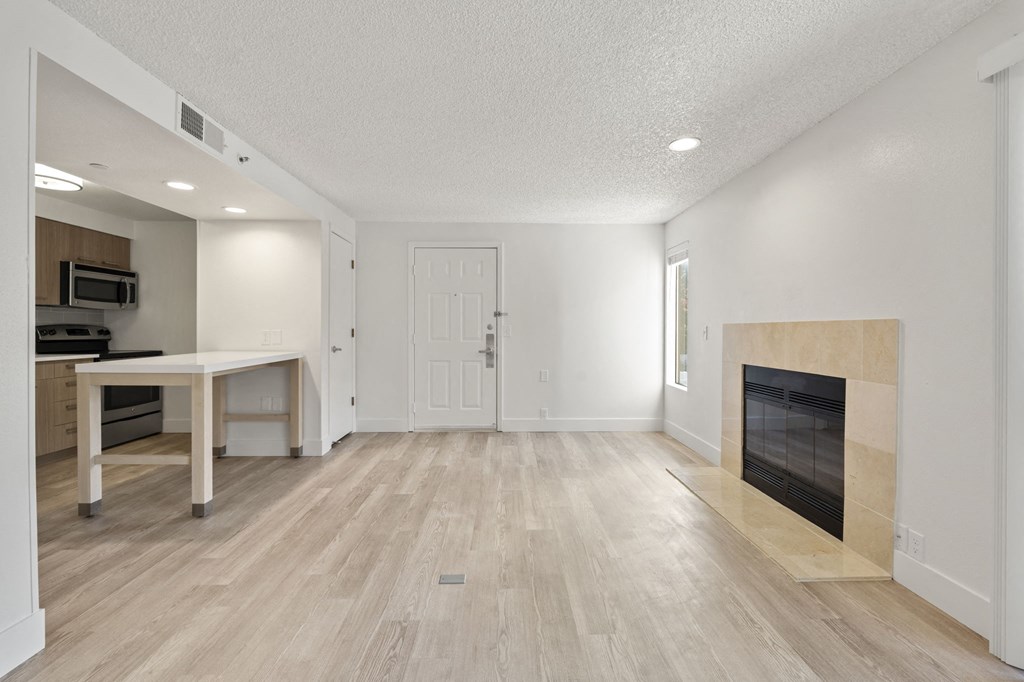 an empty living room with a fireplace and a kitchen at AVIA Lofts on Parkway Apartments, Vancouver, Washington