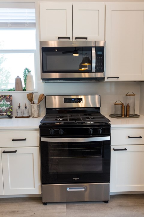 A modern kitchen with a stainless steel oven and microwave above a stove. at Alante Homes at Spring Run Flats Apartments, Idaho