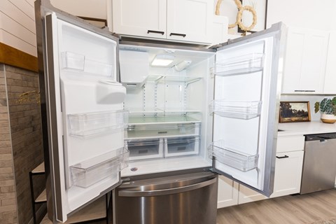A white refrigerator with its door open in a kitchen. at Alante Homes at Spring Run Flats Apartments, Caldwell, Idaho