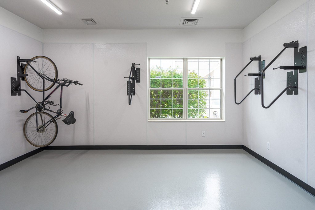 a large white room with a large window and several bikes hanging on the wall