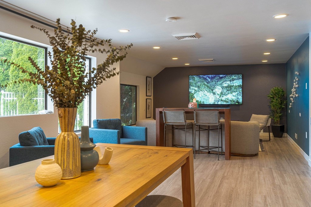 a room with a table and chairs and a tv on the wall