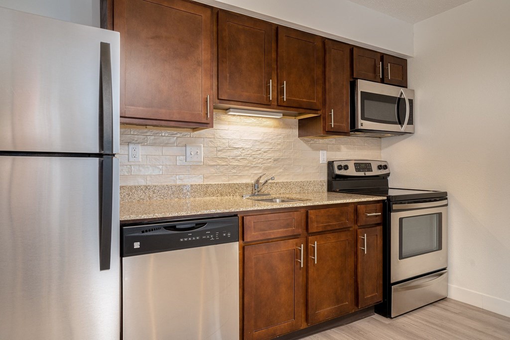 a kitchen with wooden cabinets and stainless steel appliances
