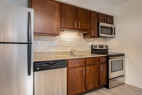 redesigned kitchen with stainless steel appliances and wooden cabinets and a granite counter top